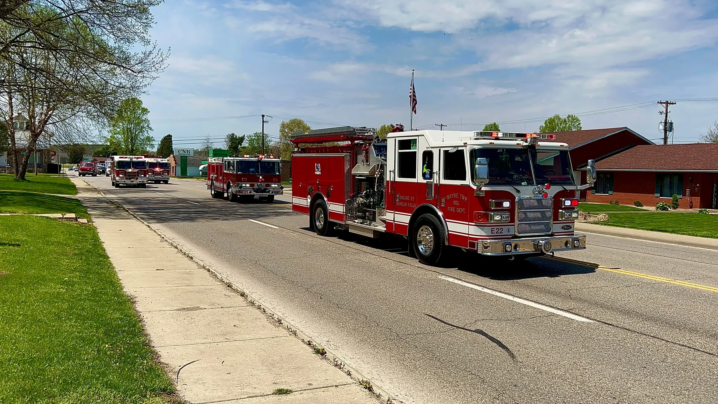 Fire apparatus lined up on a sunny street.