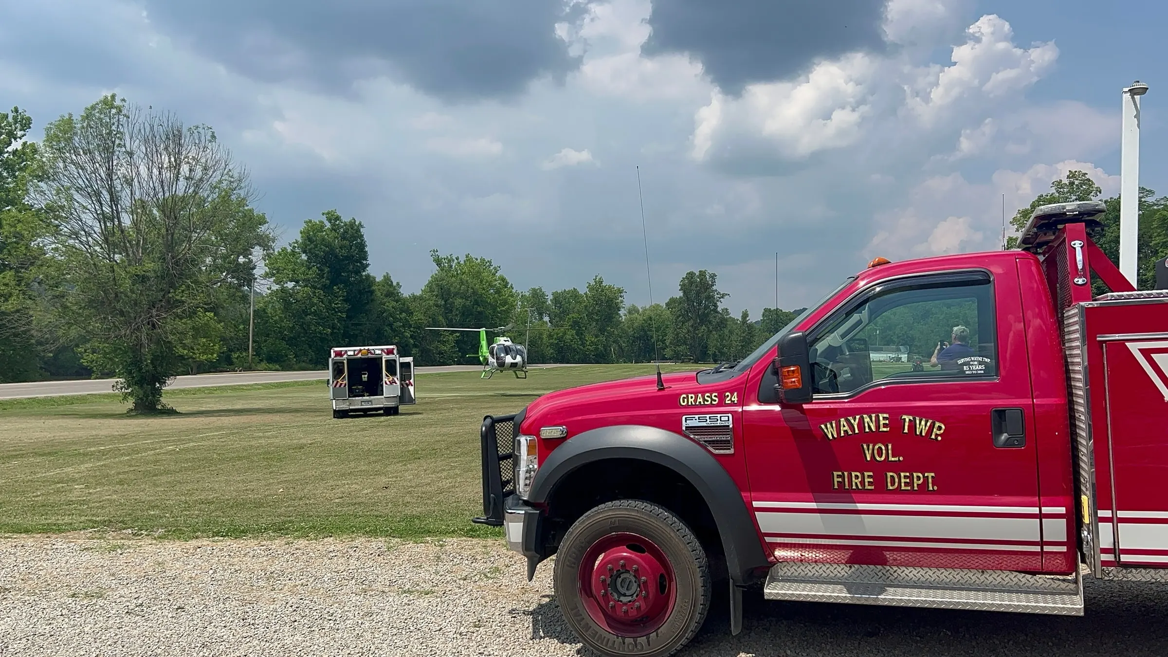 A fire engine parked near a medical helicopter on a roadway.