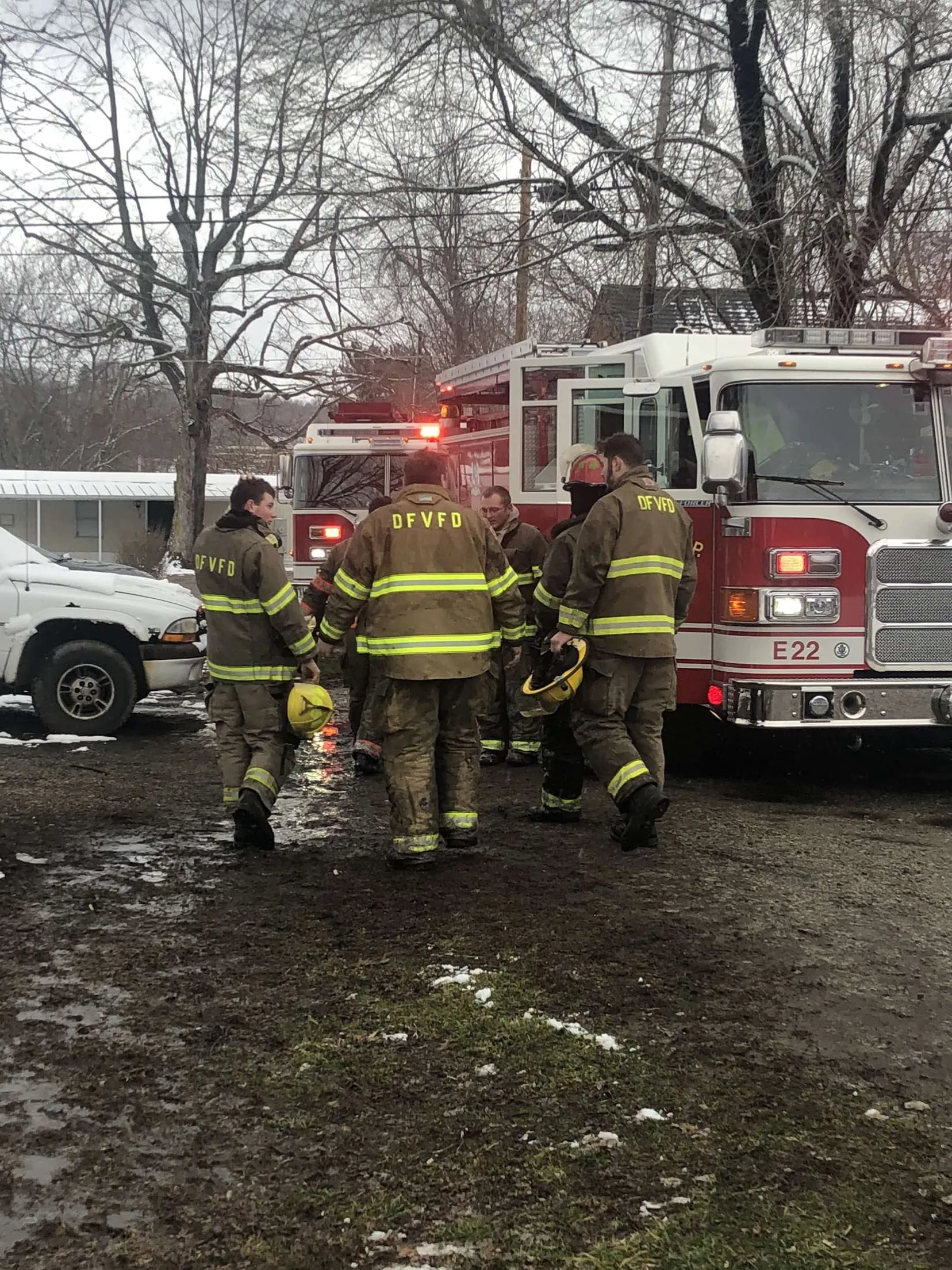 Firefighters gathered at the rear of a fire engine after a response.